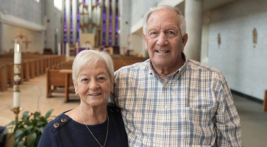 An older couple standing together inside a church